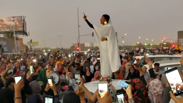 Protesting Sudanese Woman Standing on Car meme card